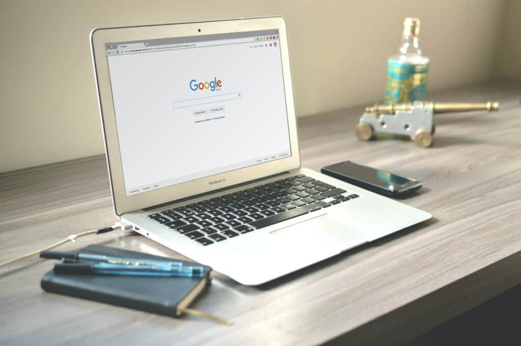 Google search on the screen - Macbook Air on Grey Wooden Table