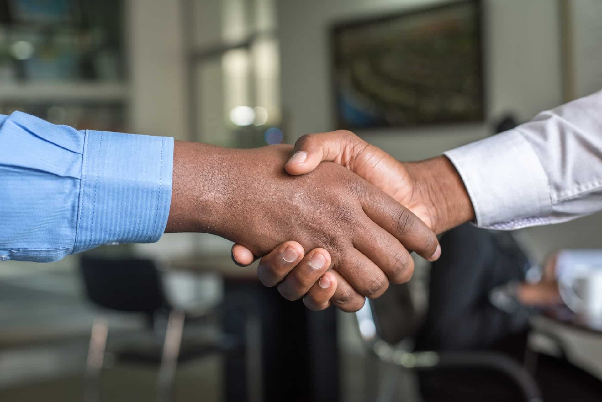 Two individuals in Long-sleeved Shirt Shakehand